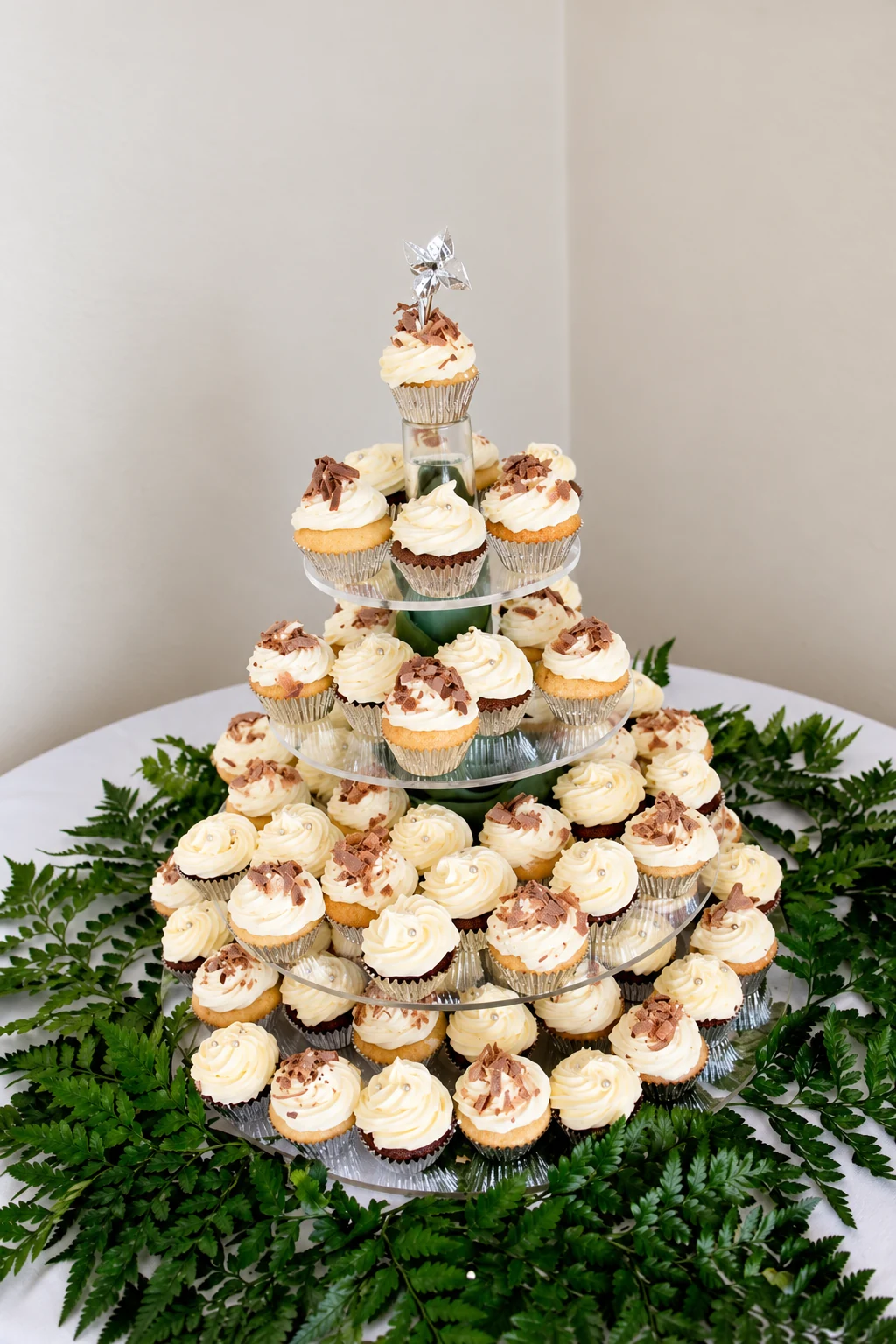 White wedding cupcake tower with greenery